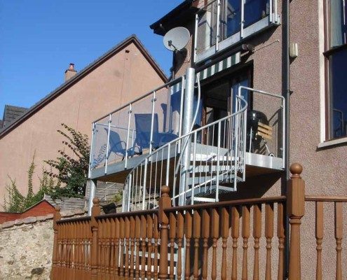 spiral staircase with large balcony with glass panels to rear of property