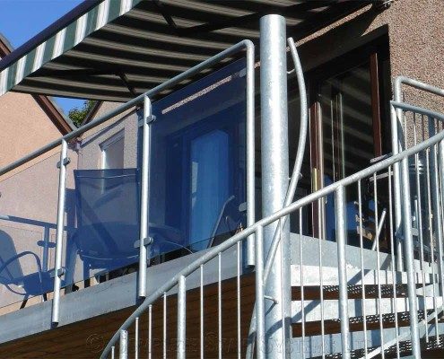 outdoor balcony with glass panels with spiral staircase