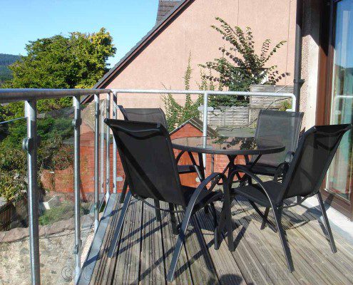 balcony with glass panels to rear of house