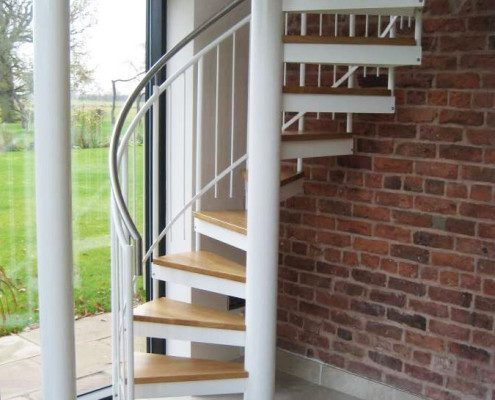 red brick wall behind a white spiral stair
