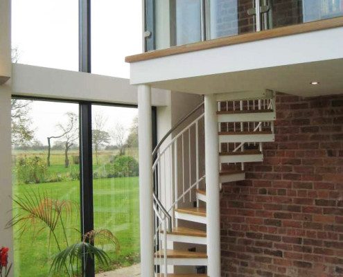 mezzanine floor with white spiral staircase with large window alongside