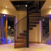 two full height windows either side of a black steel and dark wood spiral stair