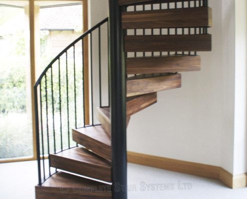 chunky walnut steps on a black steel spiral staircase