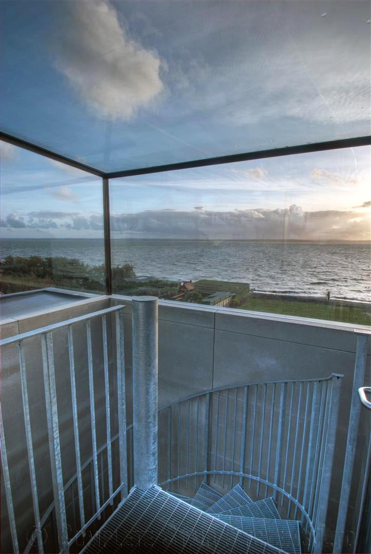 Bespoke Spiral Staircase Farnham - Steel Spiral - 4 glass box at the top of a spiral staircase with a view out to sea