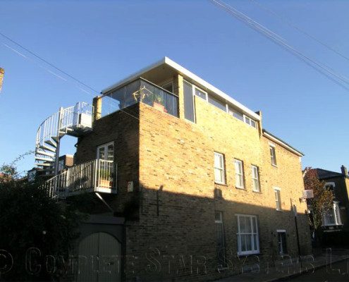 outside view of house with spiral staircase and balcony