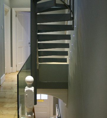 steel stair to loft above a frameless glass piece of balustrade
