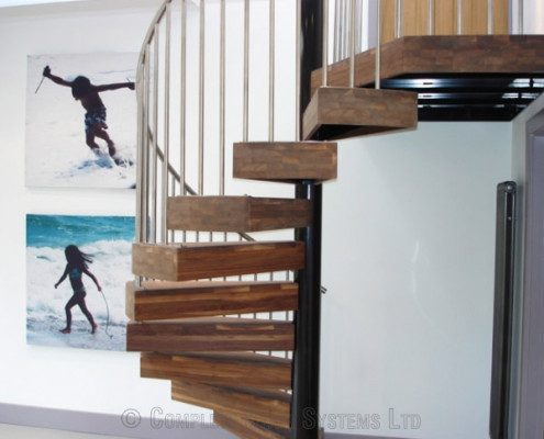 thick walnut steps on a spiral stair within a home