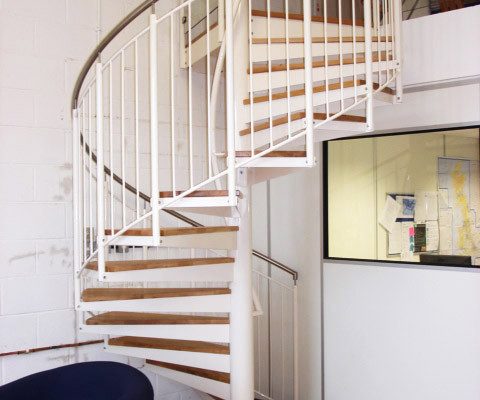 white spiral staircase with a blue chair alongside