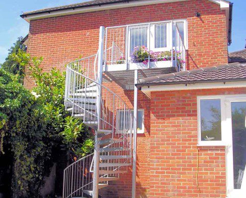 red brick house with spiral staircase and balcony