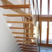 rear of open risers with oak steps with large timber framed window to front
