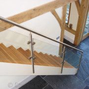 dark grey flagstone floor below a modern shite steel and glass staircase