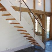 white staircase with glass panels in an oak framed house