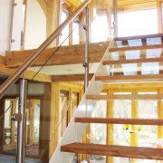glass panels to side of a white steel stair in an oak frame building