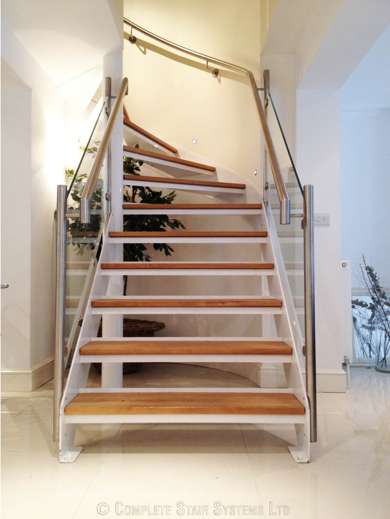 oak steps on an open riser staircase with glass panels