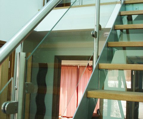 glass panels to side of grey steel open staircase