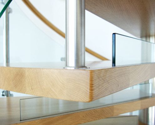 close up of an oak step on a spiral staircase with glass risers