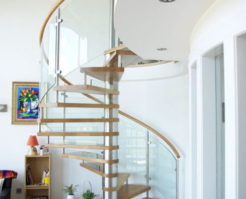 oak floor living space with a large spiral staircase with glass panels