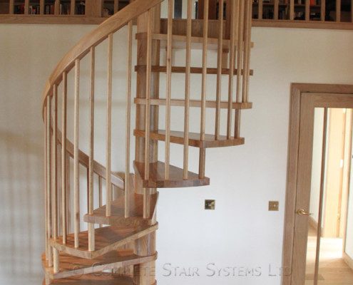 wooden spindles on a mezzanine and a wood spiral stair