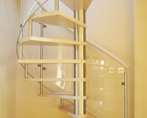 light wood spiral staircase with curved glass panels