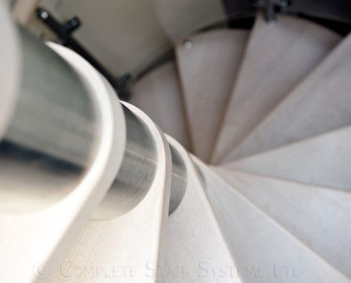 close up on light timber treads spiral staircase