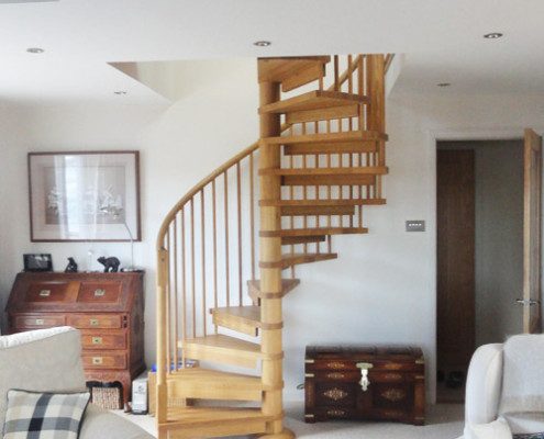 living room with white sofas and oak spiral staircase