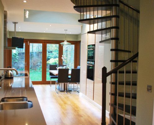kitchen work top and dining table with oak floor and spiral stair