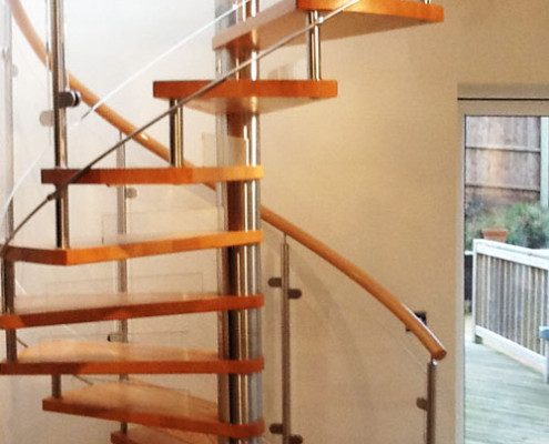 spiral stair in a house with timber handrail and curved panels