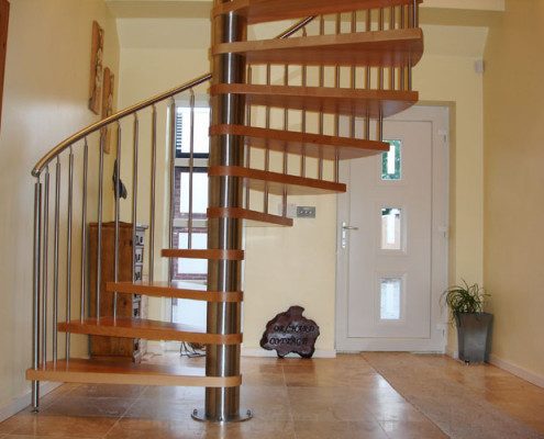 hallway with a white front door and a large spiral staircase