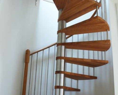 oak treads on a spiral staircase rising to a circular opening