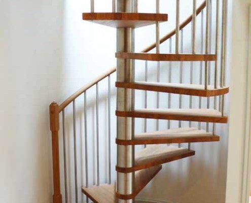 oak and stainless steel spiral staircase with curved wall behind