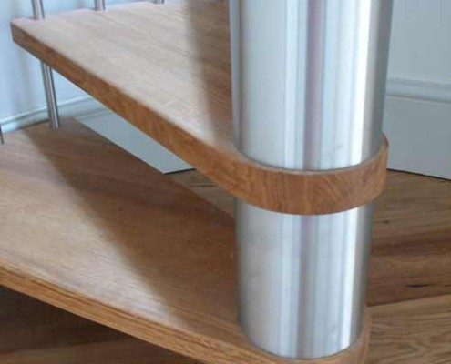 stainless steel barrels at the middle of a oak tread spiral staircase