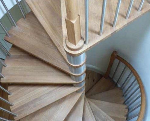 oak tread spiral staircase with stainless spindles in a circular opening