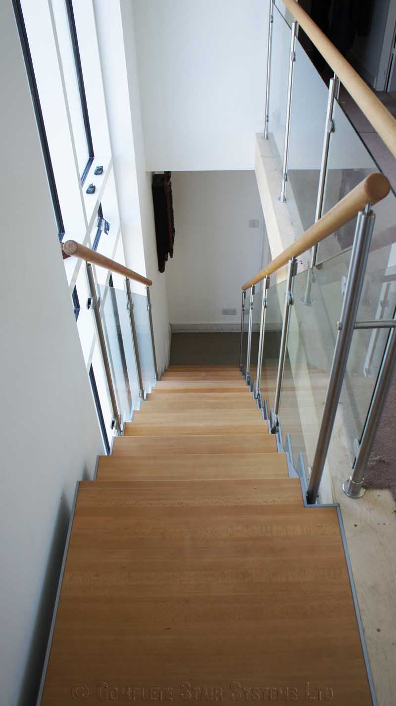 Bespoke Staircase Haslemere - Model 500 platform at the top of a straight oak and glass staircase