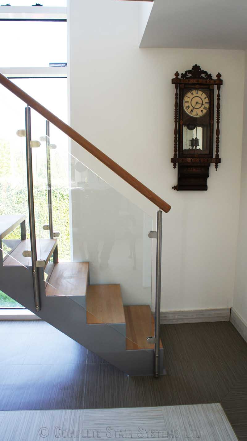 Bespoke Staircase Haslemere - Model 500 clock on wall alongside a grey steel staircase