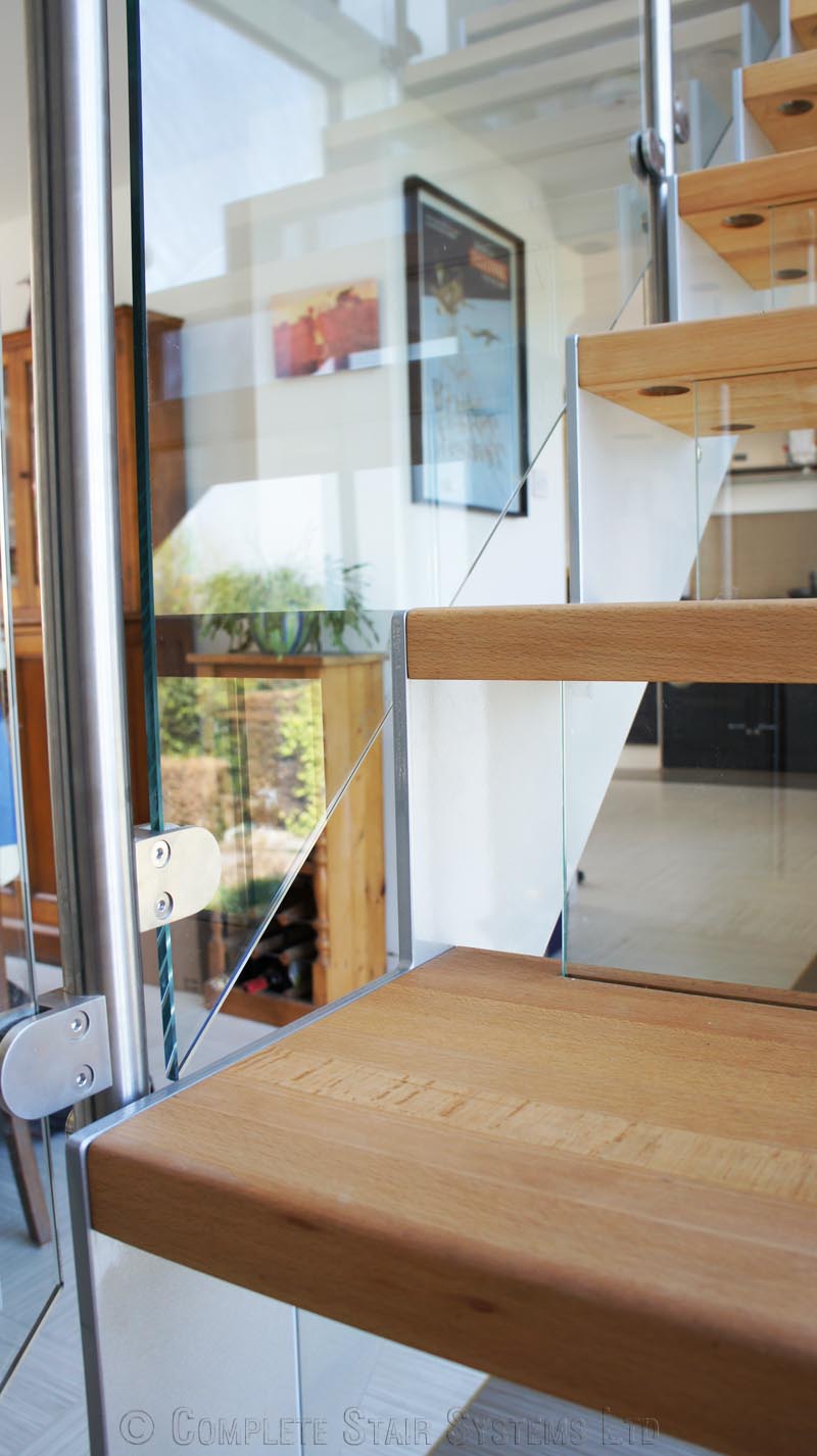 Bespoke Staircase Haslemere - Model 500 close up of glass riser on a steel and glass staircase