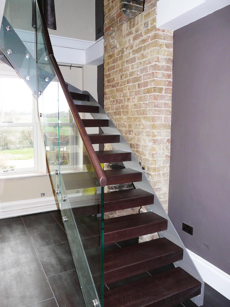 Bespoke Staircase Kent - Model 500 glass panels to the side of a dark grey and dark wood staircase