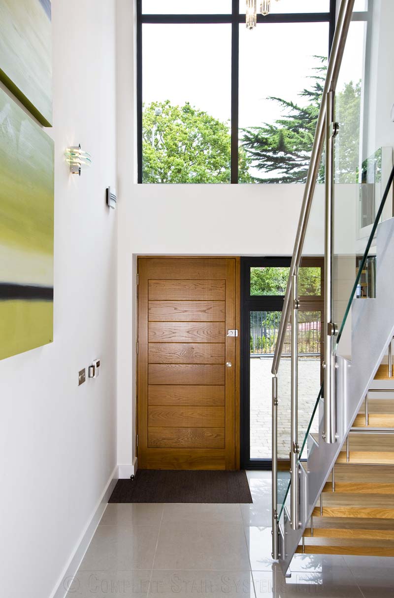 Bespoke Staircase Poole - Model 500 front door in hallway with steel and glass staircase