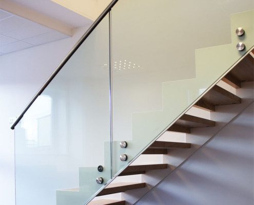Bespoke Staircase Romsey - Model 500 side of stair with glass panels and stainless handrail