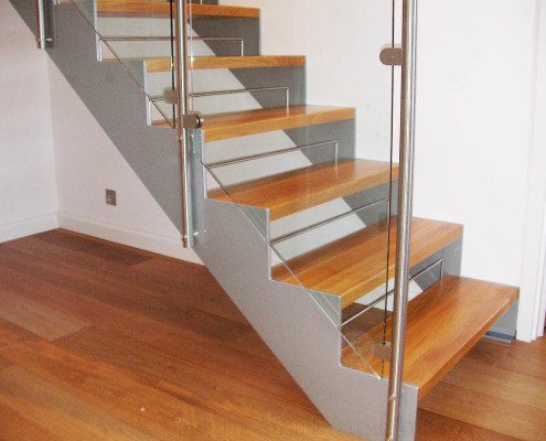 light grey steel stringers to the side of an open riser staircase