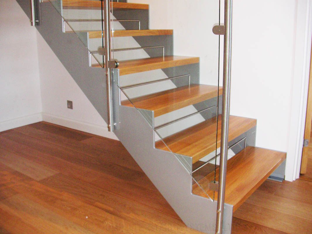 light grey steel stringers to the side of an open riser staircase