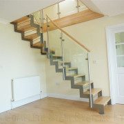 house with light wood floor and an open riser staircase with glass panels