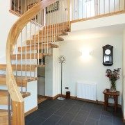 hallway with black floor and floating timber staircase