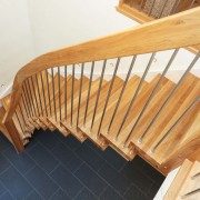 looking down a floating style oak staircase with black floor below