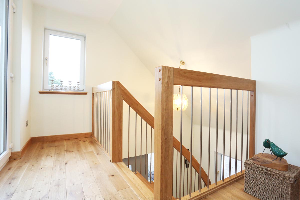 Bespoke Timber Staircase - Aberdeen landing balustrade with oak floor and stainless steel spindles around stairwell