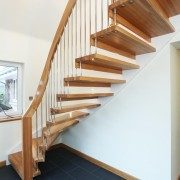black tiled floor with a curving oak staircase