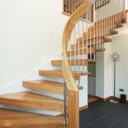 curving oak stair with black floor below