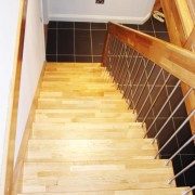 oak tread staircase with stainless spindles on a black floor