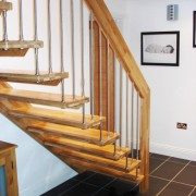 black tiled floor with oak staircase with open risers