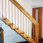 straight flight staircase with black tiled floor and white wall behind