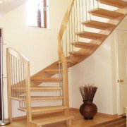 rug on floor next to floating timber staircase with curved handrail